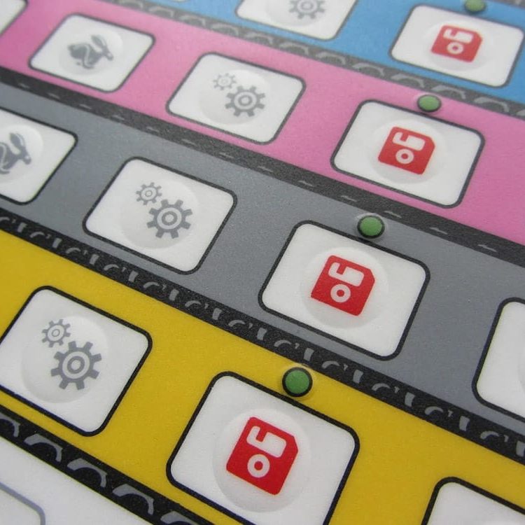 teclado de membrana fabricado por Cao Ingtec Interfaz de botones coloridos con iconos y luces en fondo gris y amarillo. Teclado de membrana