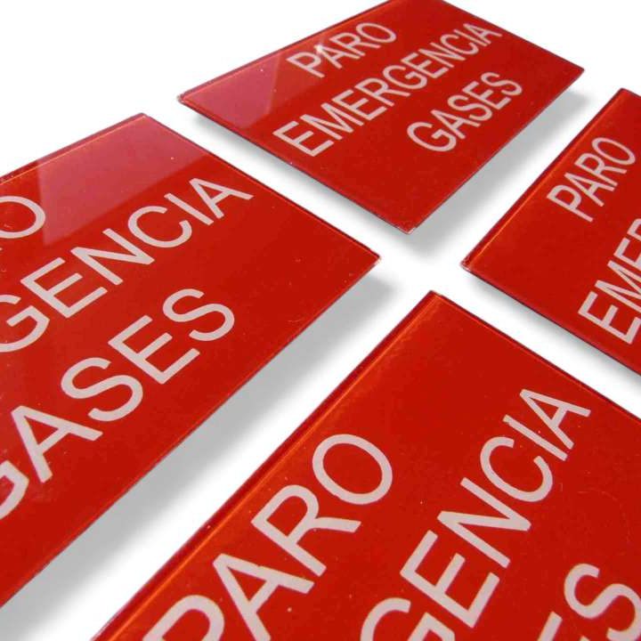 etiquetas de policarbonato para instalaciones Carteles en policarbonato brillante rojos con el texto "PARO EMERGENCIA GASES" en blanco.